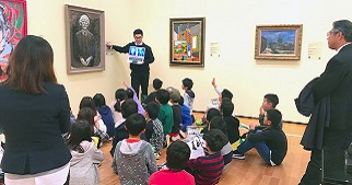 A group of students at TFAM learning about a painting 