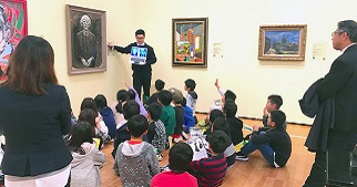 Un grupo de estudiantes en el MBAFT escuchan la explicación sobre una pintura