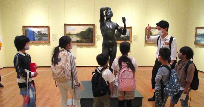 Students viewing a bronze sculpture