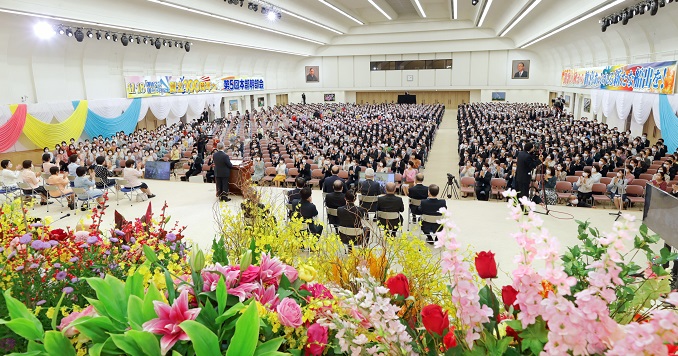 Salón lleno de personas visto desde el escenario