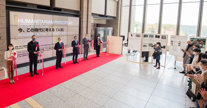A line of delegates cut the ribbon to an exhibition in a large hall