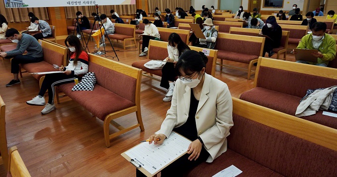 Exam participants sitting in a hall with social distancing