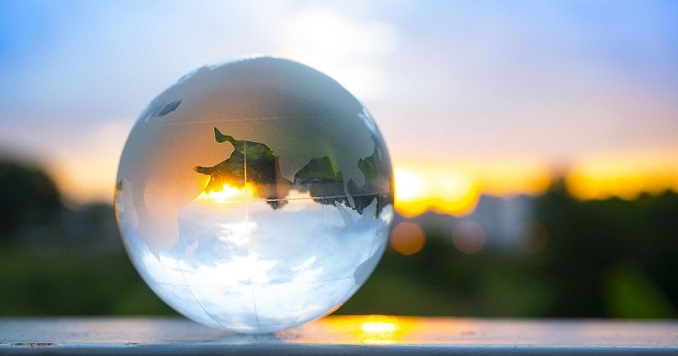 Primer plano de una esfera de cristal frente a una puesta de sol