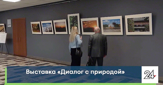 Two visitors of an exhibition viewing photographs