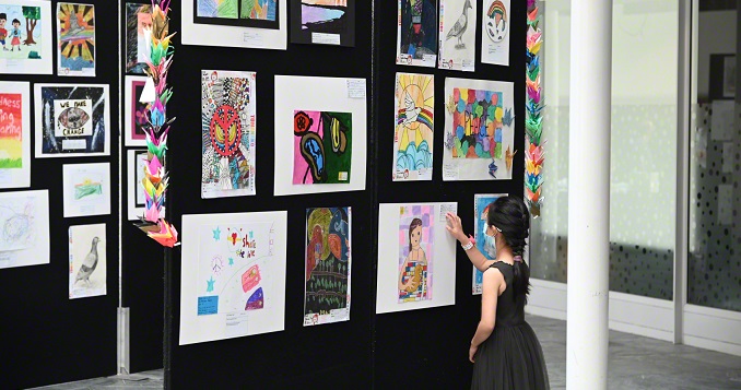 Una niña viendo obras de arte en una exposición