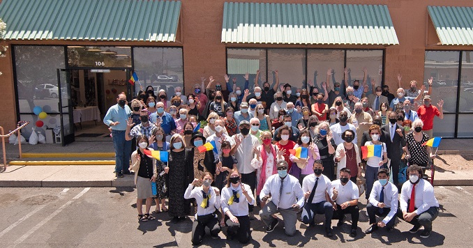 Group photo of people celebrating in front of a building posing for a commemorative picture