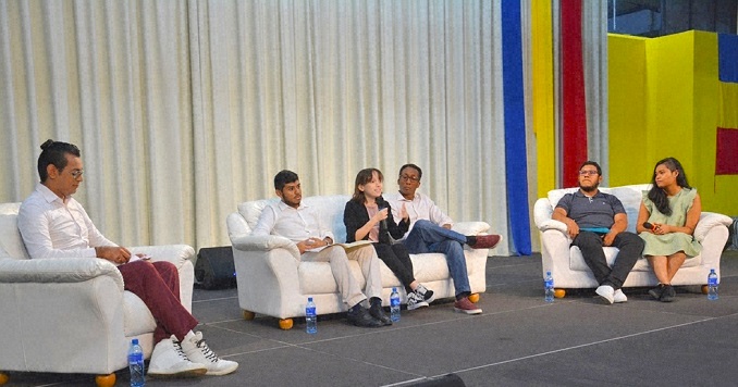 People sitting on a stage for a panel discussion