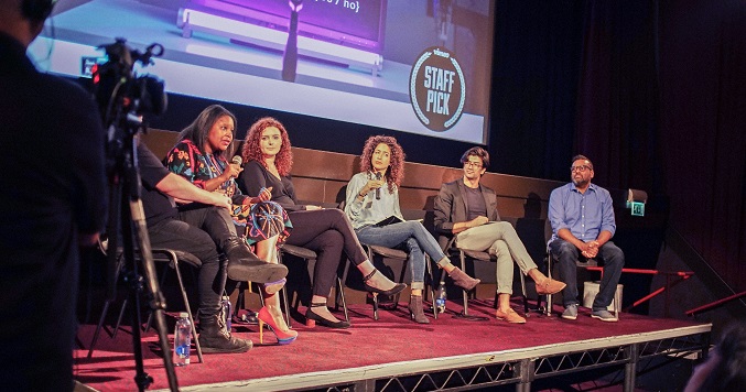 People sitting on a stage engaging in dialogue