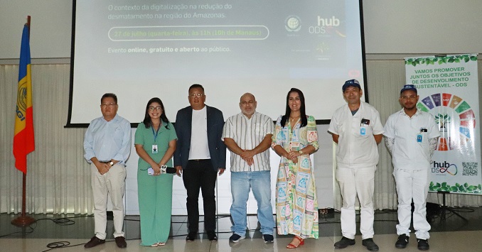 Foto de un grupo de personas posando frente a una gran pantalla