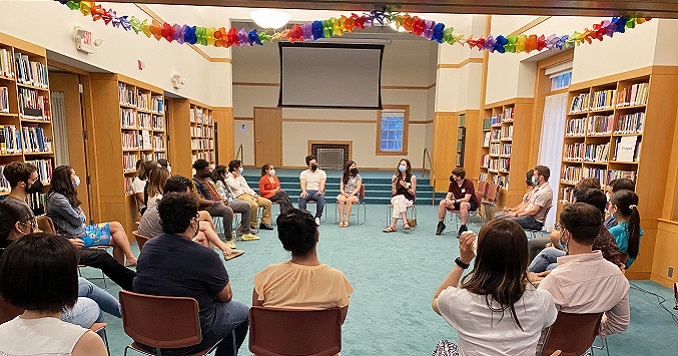 People seated on chairs in a circle listening to each other