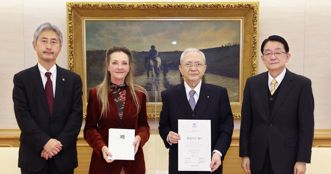 Cuatro personas posando para una foto con certificados de donación.