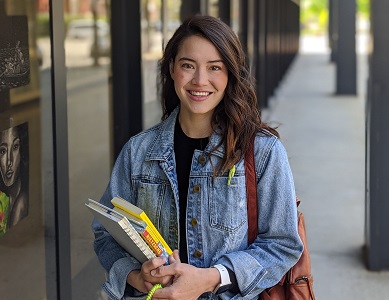 Jenny standing outside holding books