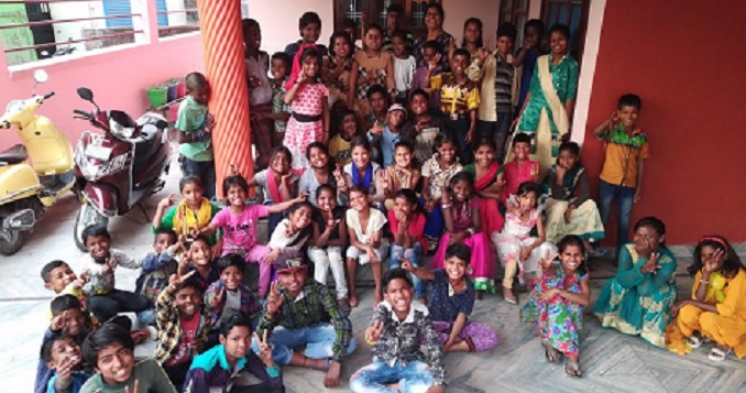 Un grupo numeroso de niñas y niños sonrientes y bien vestidos