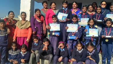 A group of uniformed students pose with certificates and medals