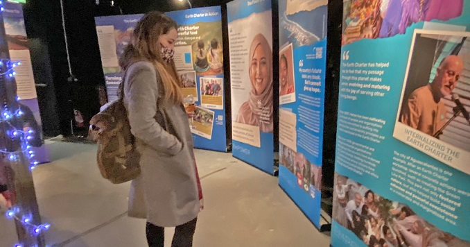 Una mujer de pie lee uno de los paneles de la exposición