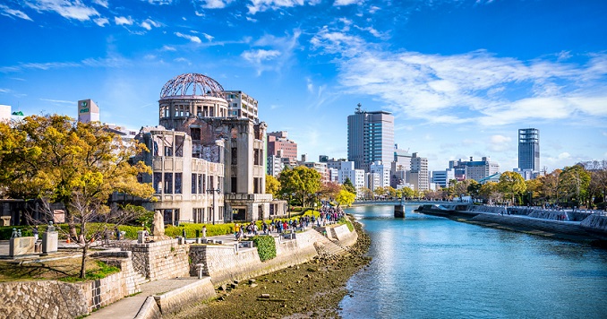 蔚藍天空下，座落在河邊的廣島原爆圓頂館。