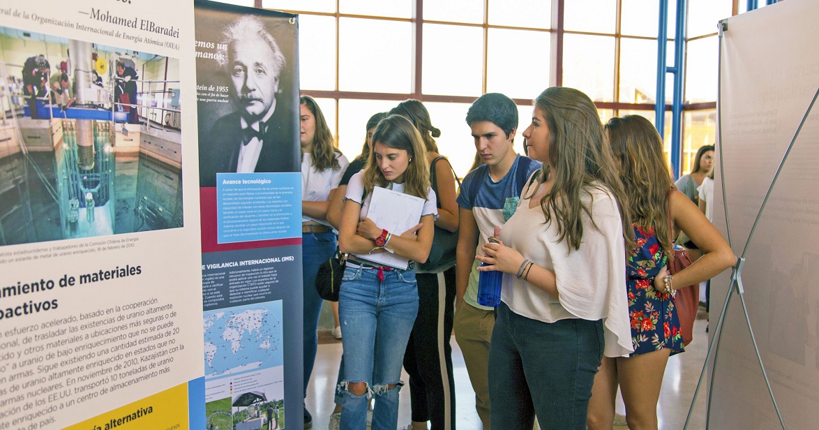 A group of young people view exhibition panels